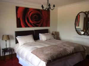 a bedroom with a bed with a painting on the wall at Lochend Farmhouse in Aberdeen