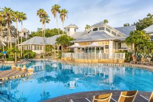 a swimming pool in front of a house with palm trees at Marriott's Cypress Harbour Villas in Orlando