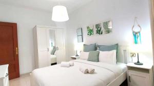 a bedroom with a large white bed with two shoes on it at Confortable vivienda en La Laguna a 5 MIN tranvía in Las Lagunas