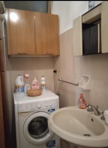y baño con lavadora y lavamanos. en Campolo Apartment, en Reggio Calabria