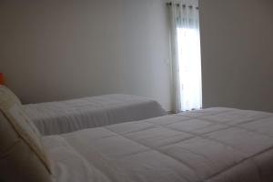 a bedroom with two beds and a window at Charming Religious House II in Fátima