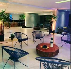 a lobby with chairs and a table in a building at Luxury Paiva Flat in Recife