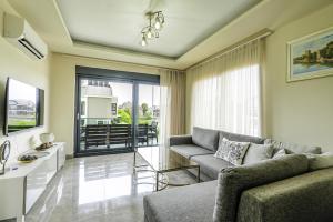 uma sala de estar com um sofá e uma mesa em Flat w Shared Pool and Balcony 8 min to Beach em Belek