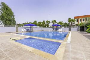 a swimming pool with blue umbrellas on top of a building at Flat w Shared Pool and Balcony 8 min to Beach in Belek