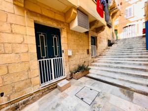 a stairway with a black door and a building at Charming Townhouse Prime Area Valletta in Valletta