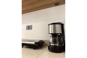 a coffee maker sitting on top of a counter at Apartamento Boqueirao Proximo a Praia, com Piscina in Praia Grande +4 photos