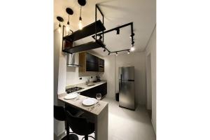 a kitchen with a counter and a refrigerator at Apartamento Boqueirao Proximo a Praia, com Piscina in Praia Grande