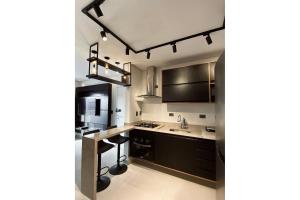 a kitchen with black cabinets and a counter top at Apartamento Boqueirao Proximo a Praia, com Piscina in Praia Grande