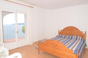 ein Schlafzimmer mit einem Bett und einem großen Fenster in der Unterkunft Villa Narcol in L'Estartit