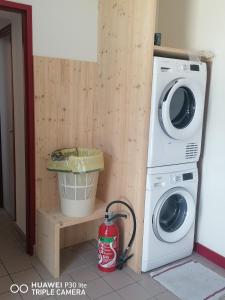 Lavadora y secadora en una habitación con cubo en Gite d'Etape de Chirac, en Chirac