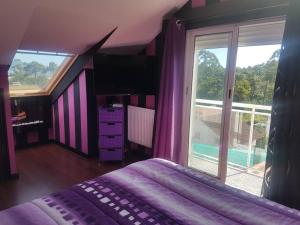 een slaapkamer met een bed en een groot raam bij Chalet con piscina en O Rosal in Rosal