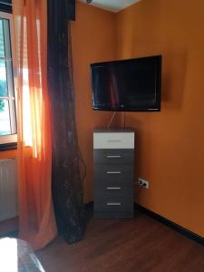 een slaapkamer met een flatscreen-tv aan de muur bij Chalet con piscina en O Rosal in Rosal