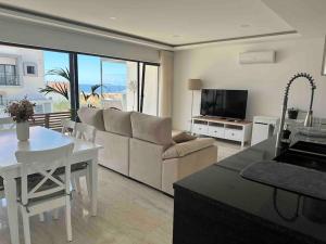 Beach, Ocean view & Bright House Ericeira في إيريسييرا: غرفة معيشة مع أريكة وطاولة