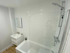 a white bathroom with a shower and a sink at Stylish & Spacious Apartment in Royal Tunbridge Wells