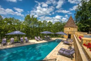 - une piscine avec des chaises longues et des parasols dans l'établissement La Perle de Domme, à Sarlat-la-Canéda