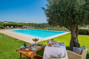 a table with food on it next to a swimming pool at Herdade da Malhadinha Nova - Relais & Châteaux in Albernoa