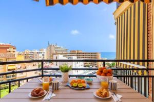 une table avec des assiettes de nourriture sur un balcon dans l'établissement Santa Amalia 39 By IVI Real Estate, à Torremolinos