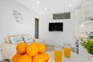 Santa Amalia 39 By IVI Real Estate في توريمولينوس: تكدس البرتقال على طاولة في مطبخ