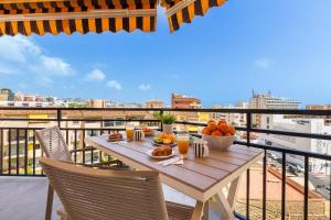 a table with a bowl of fruit on a balcony at Santa Amalia 39 By IVI Real Estate in Torremolinos