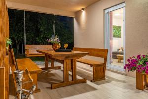 a dining room with a table and a bench at House Family Podhum in Dražice