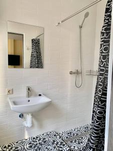 La salle de bains est pourvue d'un lavabo et d'une douche. dans l'établissement Амстердам, à Khmelnytsky