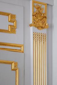 a row of gold frames on a white wall at Hotel Le Place d'Armes - Relais & Châteaux in Luxembourg +37 photos