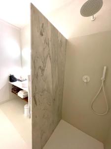 a bathroom with a shower with a marble wall at uma casa em entradas guesthouse in Entradas
