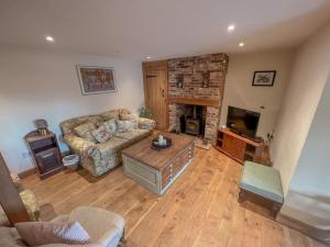 a living room with a couch and a fireplace at Sunny Dene Cottage in Knapton