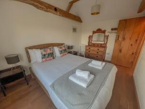 a bedroom with a bed with a mirror and a dresser at Sunny Dene Cottage in Knapton