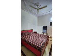 um quarto com uma cama e uma ventoinha de tecto em Hotel Prakash Inn, Bhopal em Bhopal