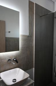 a bathroom with a sink and a shower with a mirror at Costa Varda Apartments in Mourteri