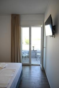 a bedroom with a bed and a door to a patio at Costa Varda Apartments in Mourteri