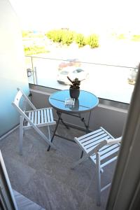 een tafel en 2 stoelen op een balkon bij Costa Varda Apartments in Mourteri