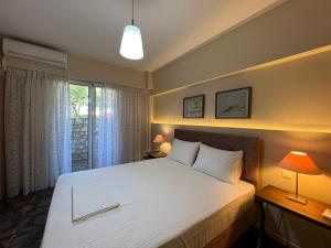 ein Schlafzimmer mit einem großen weißen Bett und einem Fenster in der Unterkunft CELENA CITY in Kalamata