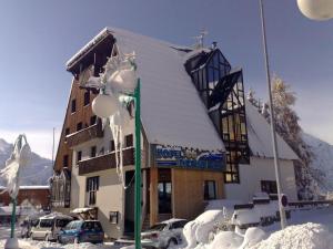 un edificio coperto di neve con auto parcheggiate di fronte di HOTEL DES NEIGES a Les Deux Alpes