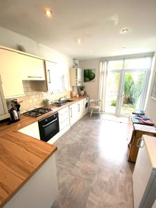 a kitchen with white appliances and a large window at Palm House -Complete Holiday HOME IN SOUTHSEA in Portsmouth