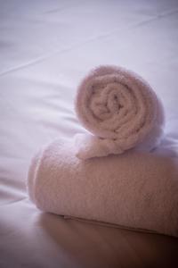 a white towel sitting on top of a bed at HOTEL DES NEIGES in Les Deux Alpes