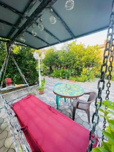 a patio with a table and a red blanket at Eliz Garden in Kutaisi