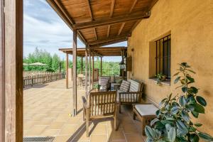 an outdoor patio with chairs and awning at Mas Alba in San Esteban de Guialbes