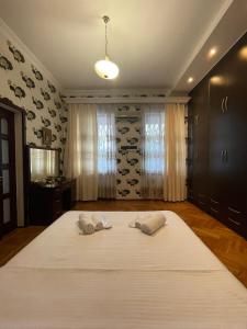 a bedroom with a large bed with two pillows on it at Eliz Garden in Kutaisi