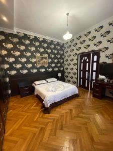 a bedroom with a bed and floral wallpaper at Eliz Garden in Kutaisi