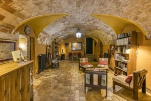 Una sala de estar con una pared de piedra y una biblioteca. en Mas Alba, en San Esteban de Guialbes