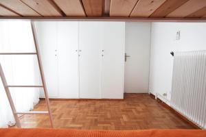 an empty room with white cabinets and a wooden floor at Eva's Urban Apt in Athens 6' to Transit Station in Athens