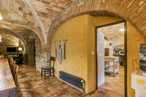 una habitación con una pared de ladrillo y una chimenea en Mas Alba, en San Esteban de Guialbes