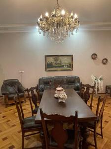 a dining room with a table and chairs and a chandelier at Eliz Garden in Kutaisi