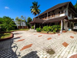 un bâtiment avec un palmier en arrière-plan dans l'établissement AZZA Heritage Home, à Cochin