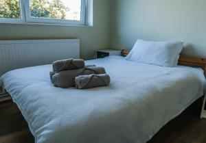 a bed with two towels sitting on top of it at Comfortable Room-Only Room in London