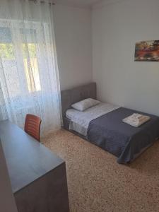 Schlafzimmer mit einem Bett, einem Schreibtisch und einem Fenster in der Unterkunft Athena Apartment in Lecce