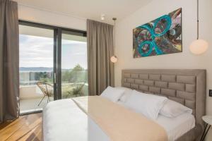 a bedroom with a large bed and a balcony at Villa Maris - Luxury Villa with Pool in Brodarica +59 photos