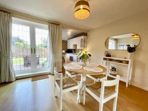 a kitchen and dining room with a table and chairs at Cosy Croft Cottage in Greasbrough